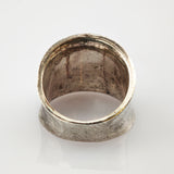 Nahaufnahme eines alten silbernen Rings mit breitem Band und sichtbarer Patina auf weißem Hintergrund