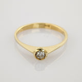 Eleganter Goldring mit rund geschliffenem Diamant in Fassettensitz auf weißem Hintergrund.