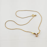 Feine Goldkette mit Anhänger aus flügelförmigen Goldelementen und Diamanten auf weißem Hintergrund.