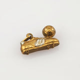 Goldener Anhänger in Fußballschuhform mit silbernen Streifen und kleinem Fußball mit hexagonalen Mustern.
