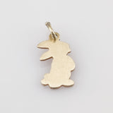 Kleiner goldener Anhänger in Form eines stilisierten Hasen mit Öse für Kette oder Armband.