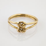 Goldener Ring mit Doppelband und zwei verflochtenen Knoten, minimalistisch und elegant.