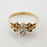 Goldener Ring mit feinem Design und sieben kleinen, runden weißen Steinen in Kreuzanordnung auf schmalem Band.