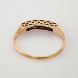 Goldener Ring mit filigranen Ausschnitten und elegantem Hohlraummuster auf hellem Hintergrund