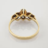 Goldener Ring mit kronenförmigem Fassungsdesign und mehreren Steinen, von unten aufgenommen.