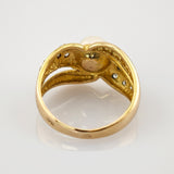 Nahaufnahme eines goldenen Rings mit Perle und detaillierter Innenstruktur, die feine Handwerkskunst zeigt
