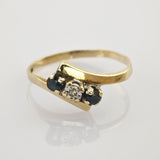 Goldener Ring mit rechteckigem Aufsatz und klaren sowie dunklen Edelsteinen