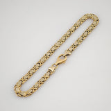 Goldenes Kettenarmband mit rechteckigen Gliedern und polierter Oberfläche auf weißem Hintergrund.