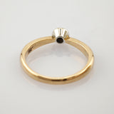 Goldring mit Weißgoldfassung und dunklem mittigem Loch, minimalistisches und elegantes Design.