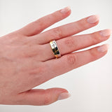 Linke Hand mit blassrosa lackierten Nägeln trägt zweifarbigen Ring aus Gold und Silber mit Diamant.