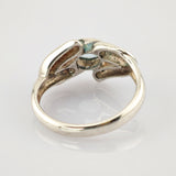 Metallring mit zwei Händen, die einen blauen Edelstein halten. Eleganter Vintage-Schmuck.