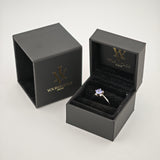 Schwarze Schmuckbox mit Silberring und violettem Edelstein auf schwarzem Samt mit Goldlogo von yourvintoge.shop.