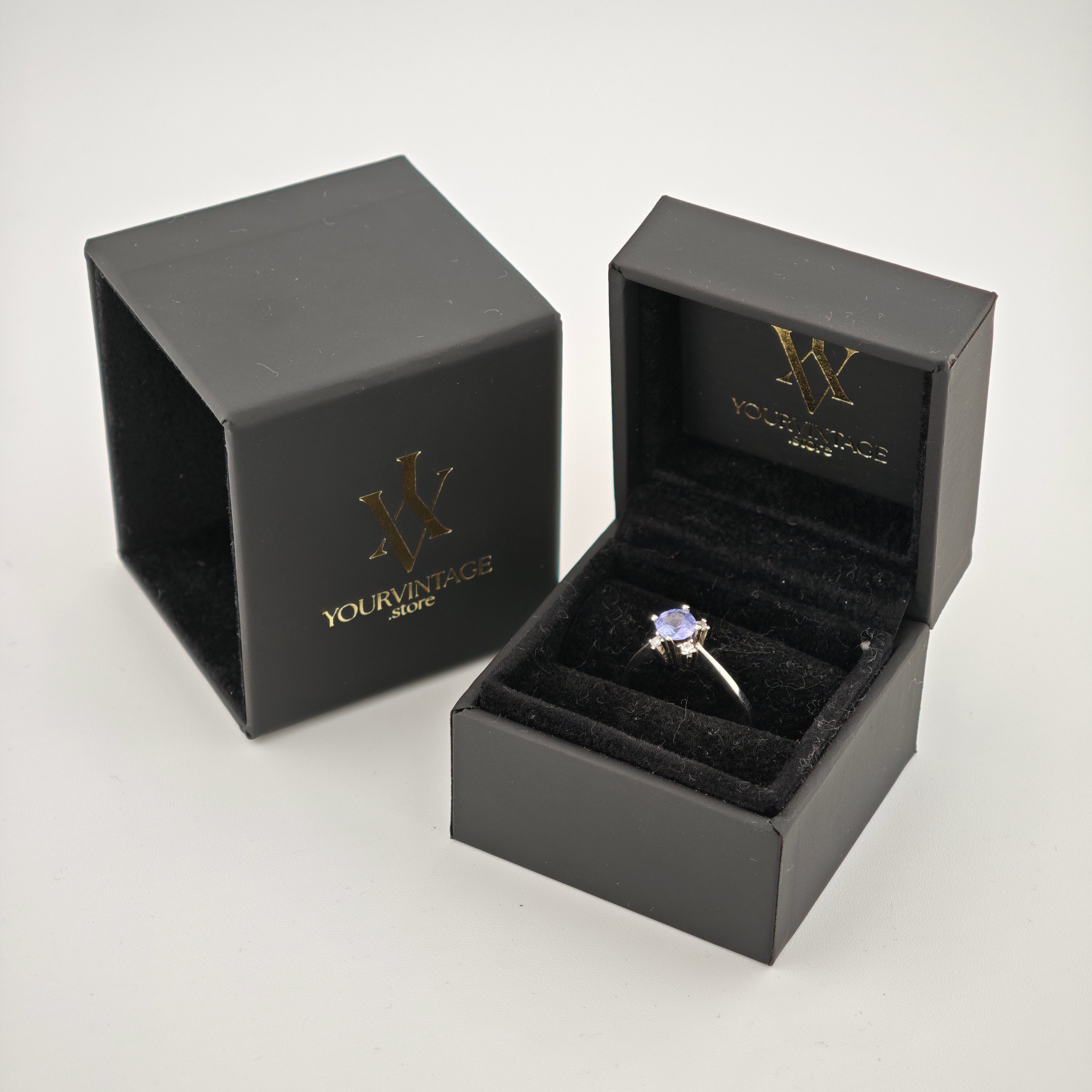 Schwarze Schmuckbox mit Silberring und violettem Edelstein auf schwarzem Samt mit Goldlogo von yourvintoge.shop.