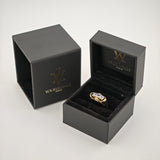 Schwarze Schmuckschachteln mit goldenem 'W'-Logo und Text 'yourvintoge.shop', offene Schachtel zeigt goldenen Ring mit drei klaren rechteckigen Edelsteinen.