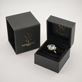 Zwei schwarze Schmuckschatullen, eine geschlossen mit goldener Aufschrift 'yourvintoge.shop', die andere offen mit einem Goldring und blauem Edelstein.