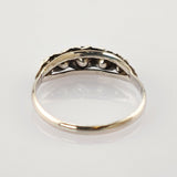 Silberfarbener Ring mit sichtbarer Innenseite und Fassung auf spiegelnder weißer Oberfläche