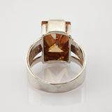 Silberner Ring mit rechteckigem, bernsteinfarbenem Stein und geteiltem Band mit strukturierter Innenseite