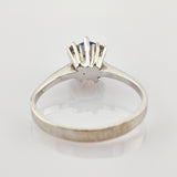 Silberner Ring mit blauem Edelstein in Krappenfassung und eingravierter 14K-Markierung auf dem Innenring.