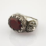 Silberner Ring mit facettiertem dunkelrotem Edelstein und viktorianischem Muster
