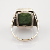Silberner Ring mit quadratischem grünem Edelstein und texturierten Details am Ringband.
