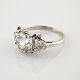 Eleganter silberner Ring mit herzförmigem und dreieckigen Edelsteinen auf schlichtem Band