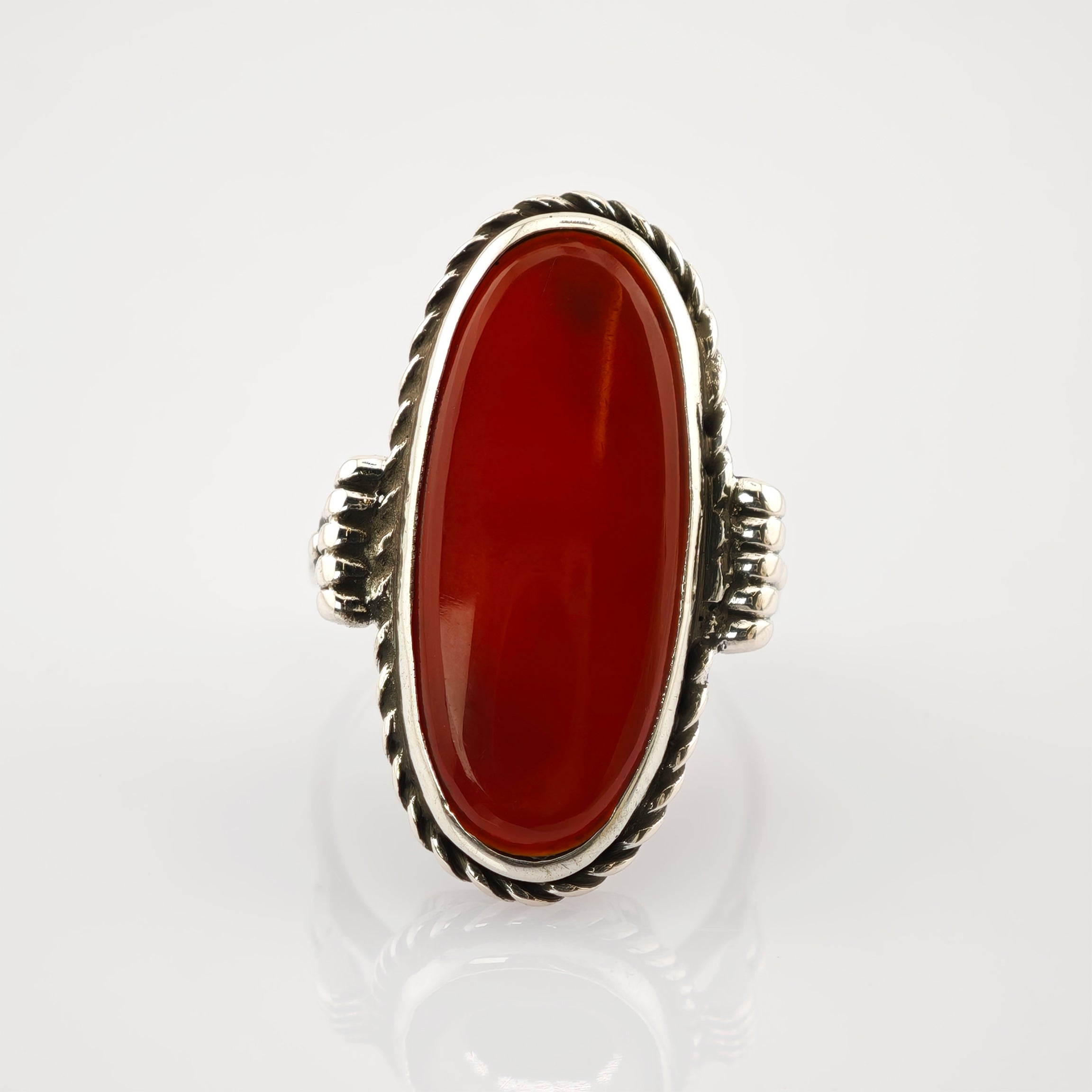Silberner Ring mit langem ovalen roten Edelstein in gedrehter Seilfassung und detaillierten Silberakzenten.