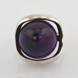 Silberner Ring mit quadratischem Rahmen und großem rundem violetten Stein in der Mitte
