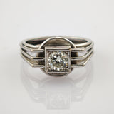 Silberner Ring mit großem rund geschliffenem Diamanten in quadratischer Fassung und dreiteiligem Band.