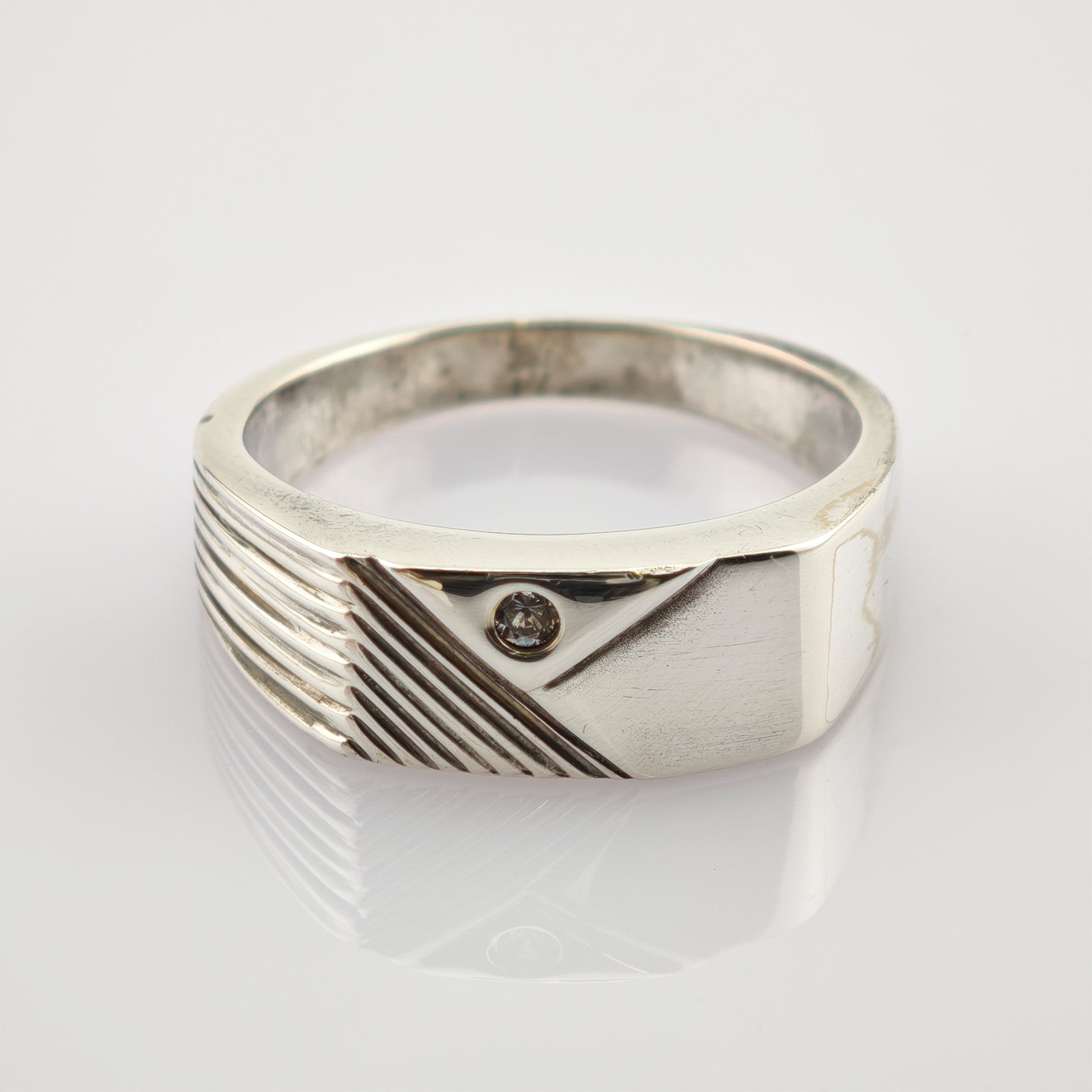 Silberring mit asymmetrischem Design, diagonalen Gravurlinien und kleinem runden Edelstein
