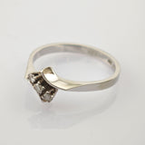 Eleganter Silberring mit drei kleinen runden Diamanten im Dreiecksmuster und gebogener Bandform.