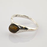 Silberring mit dreieckigem poliertem Bernstein und goldbraunen Einschlüssen auf einem glatten Silberband