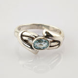Silberring mit ovalem blauem Edelstein und geschwungenem Band, 925 Sterlingsilber.