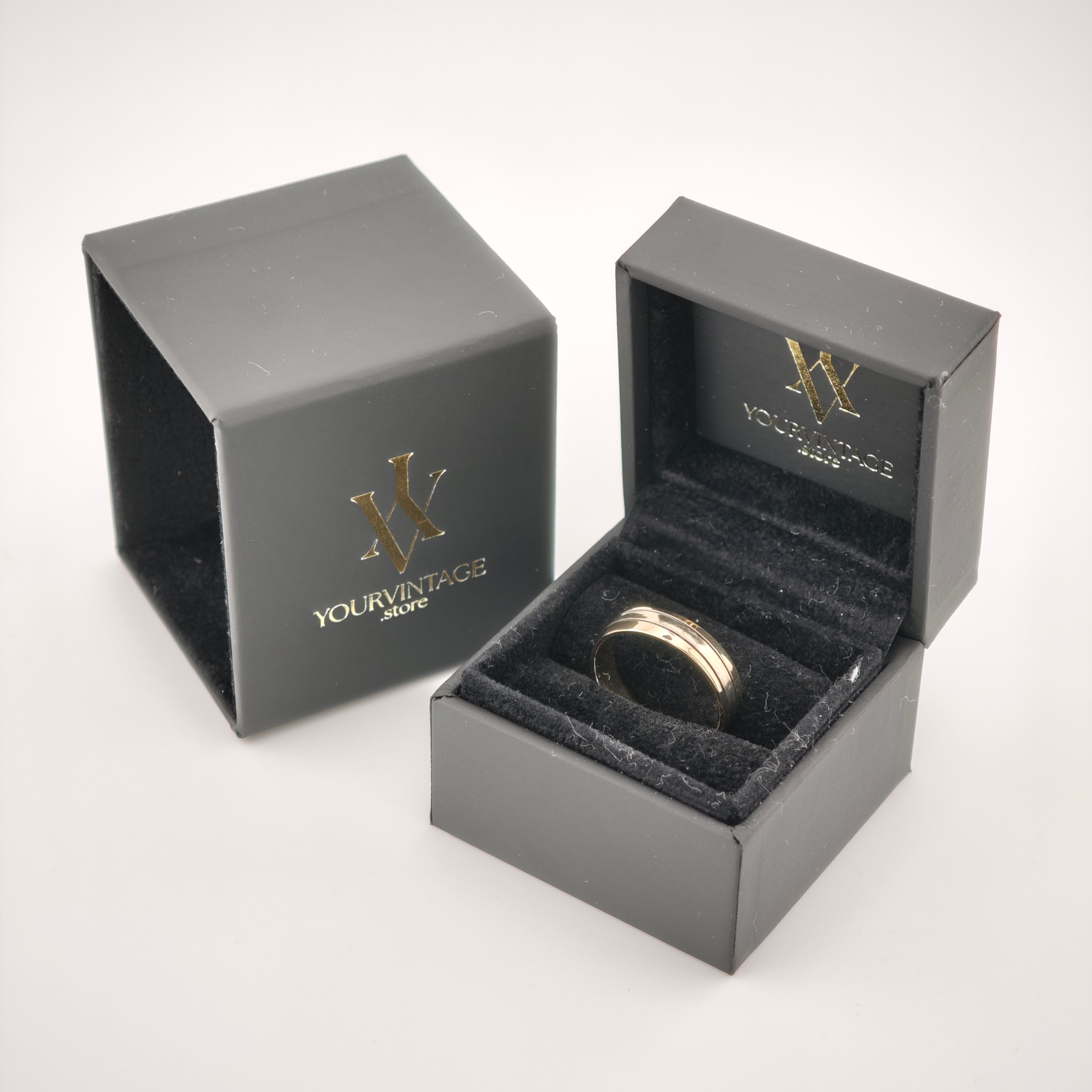 Zwei elegante schwarze Ringboxen mit goldfarbenem yourvintoge.shop Logo, eine geöffnet mit goldenem Ring auf schwarzem Samt