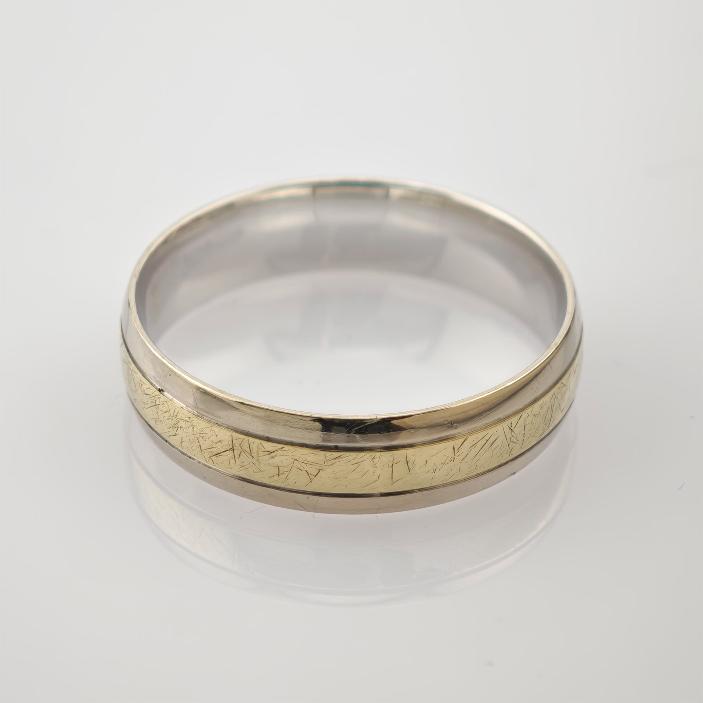 Nahaufnahme eines zweifarbigen Rings mit silberner Außenkante und goldfarbener Innenseite.